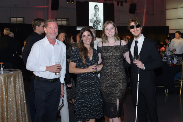 Four people in dress clothes standing together for a photo.