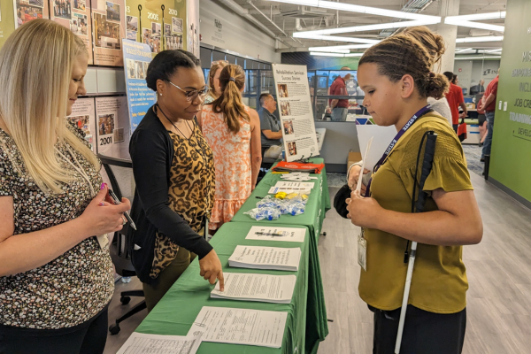 A young girl talking to someone at a career expo.