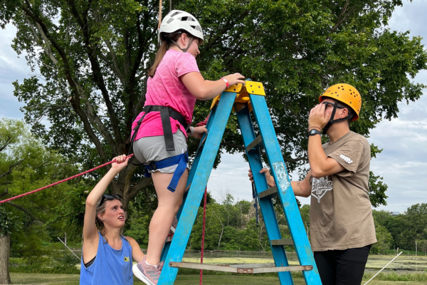 A young girl climbing on a ladder.