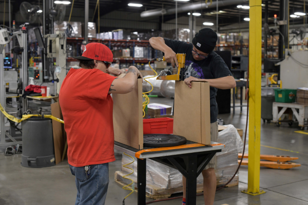 Two blind employees working on packaging kits.