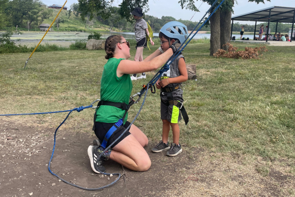 A boy having a helmet placed on his head.