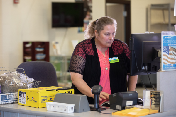 A cashier who is blind working.