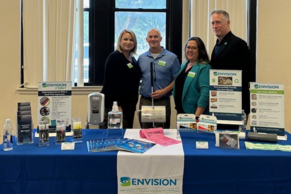 Marcie Shaffer, Andy Hoffman, Kathy Vines and Buddy Sell standing behind an Envision table.