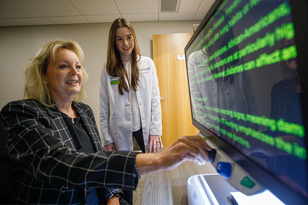 Woman learning to use a large screen for accessibility in the Envision Dallas Vision Rehabilitation Center