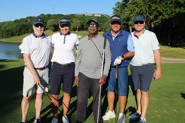 Golf team stands with Sam Jackson on the green.